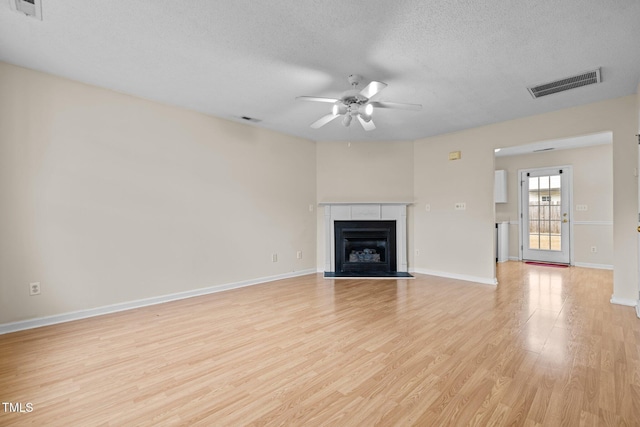 unfurnished living room featuring ceiling fan, a textured ceiling, and light hardwood / wood-style floors