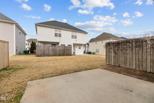 back of house featuring a yard, central AC, and a patio area