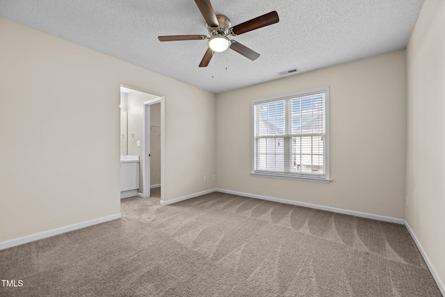 carpeted spare room featuring ceiling fan and a textured ceiling