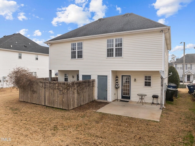 rear view of house featuring a patio and a lawn