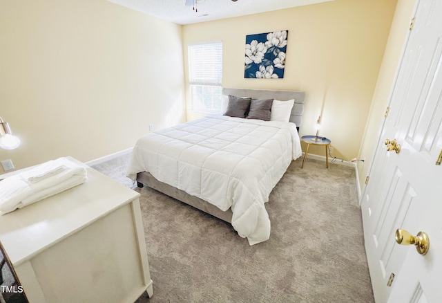 carpeted bedroom with ceiling fan and a textured ceiling