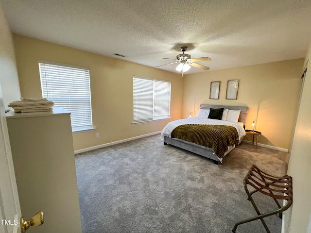 carpeted bedroom with ceiling fan and a textured ceiling