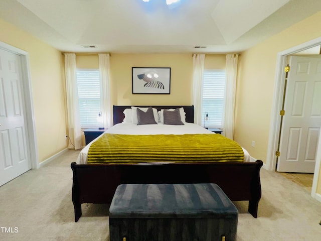 bedroom with baseboards, visible vents, and light colored carpet