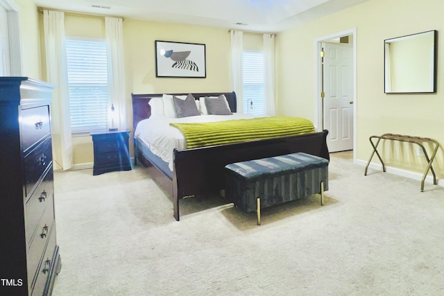 carpeted bedroom with multiple windows, visible vents, and baseboards