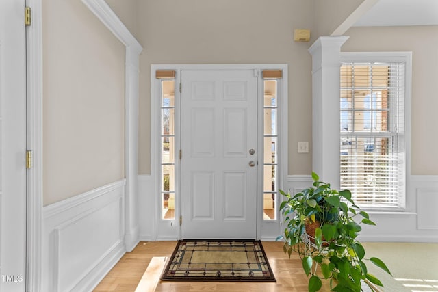 entrance foyer with light hardwood / wood-style floors and decorative columns