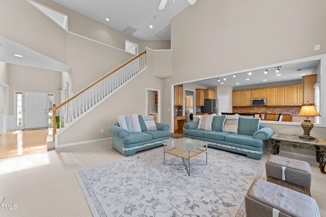 living room with a healthy amount of sunlight, light carpet, and a high ceiling