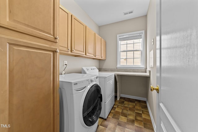 clothes washing area with cabinets and washing machine and dryer