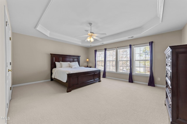 bedroom featuring a tray ceiling, light colored carpet, and ceiling fan