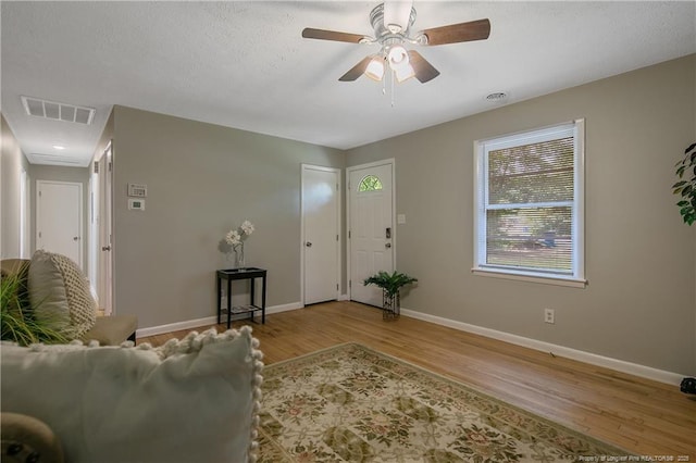 living room featuring ceiling fan and light hardwood / wood-style flooring