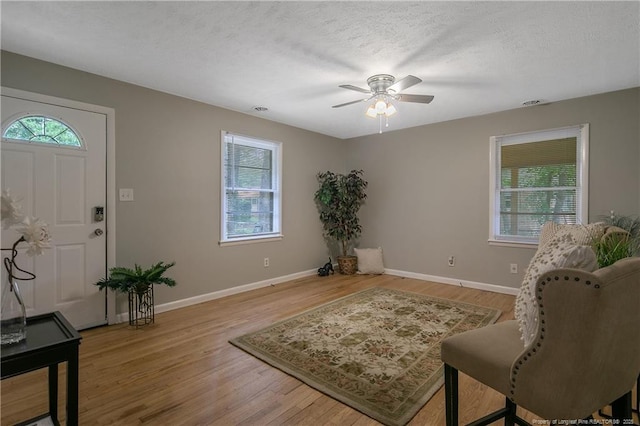 interior space featuring hardwood / wood-style flooring, ceiling fan, and a textured ceiling