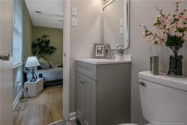 bathroom featuring hardwood / wood-style flooring, vanity, and toilet