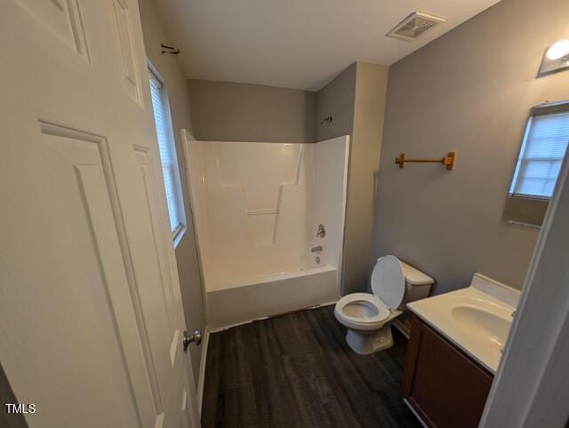 bathroom featuring visible vents, toilet, shower / bath combination, wood finished floors, and vanity