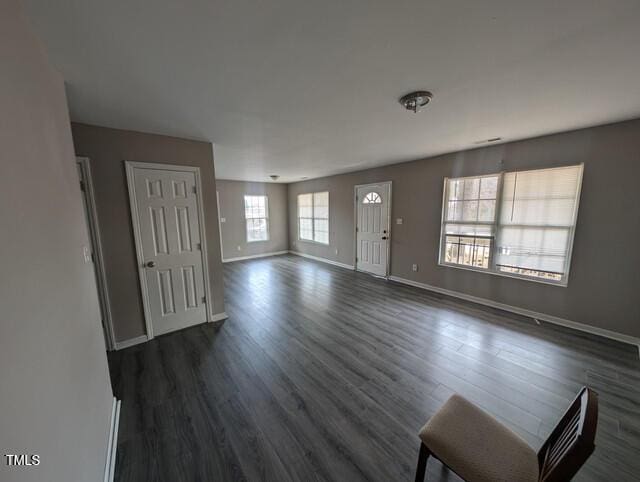 entryway featuring baseboards and dark wood-style flooring