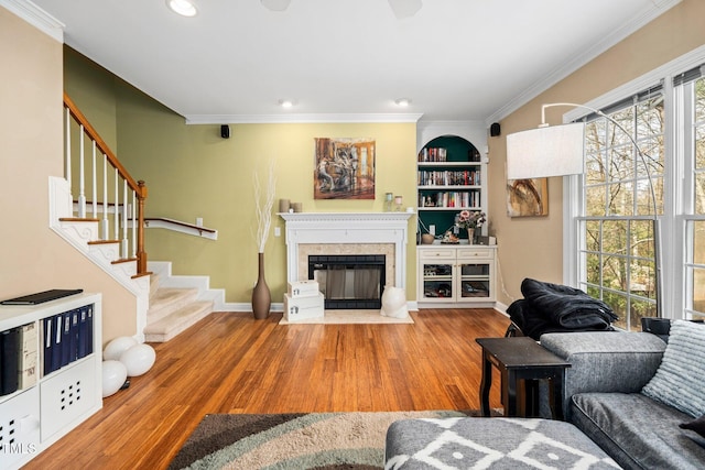 living room featuring ornamental molding, hardwood / wood-style floors, and built in shelves