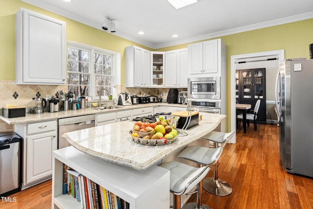 kitchen with white cabinetry, stainless steel appliances, and a center island