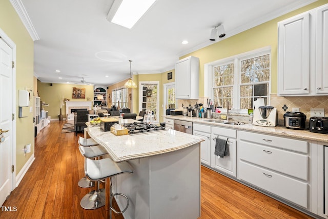 kitchen with backsplash, crown molding, a breakfast bar area, and white cabinets