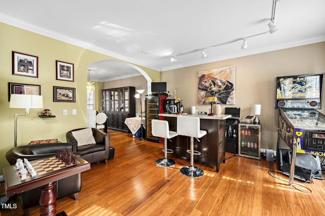 bar featuring wine cooler, wood-type flooring, and ornamental molding