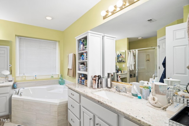 bathroom with vanity and shower with separate bathtub