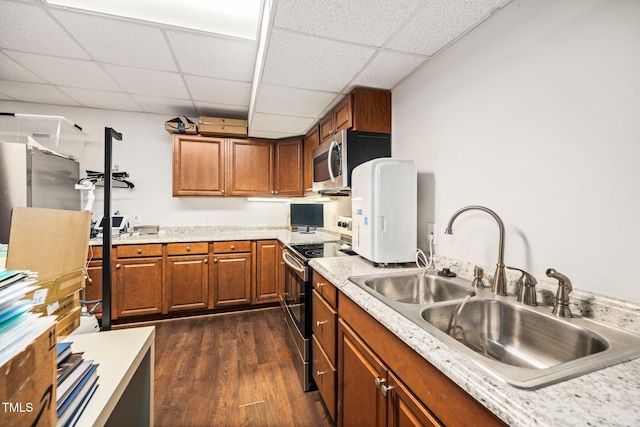 kitchen with sink, dark wood-type flooring, stainless steel appliances, and a paneled ceiling