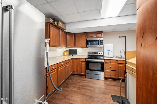 kitchen with stainless steel appliances, a paneled ceiling, dark hardwood / wood-style floors, and sink