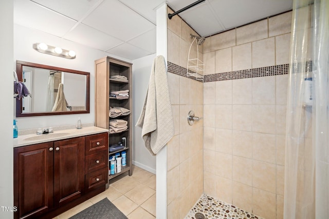 bathroom with tiled shower, tile patterned floors, and vanity