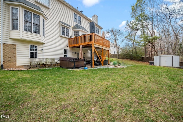 view of yard with a hot tub, a deck, and a shed