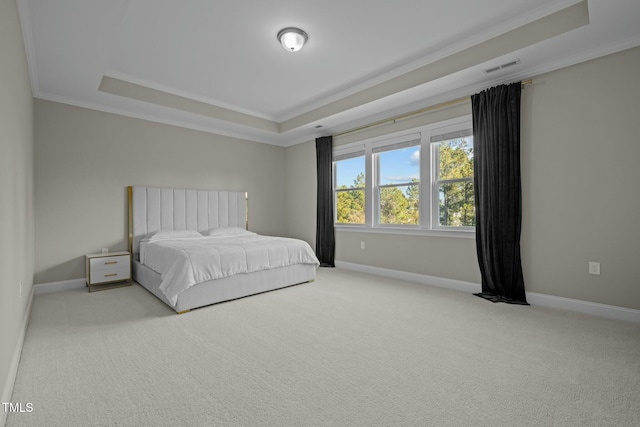 carpeted bedroom with crown molding and a tray ceiling