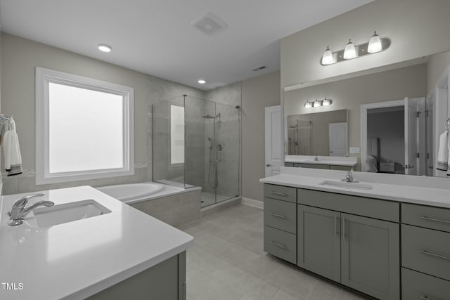 bathroom featuring independent shower and bath, vanity, and tile patterned floors