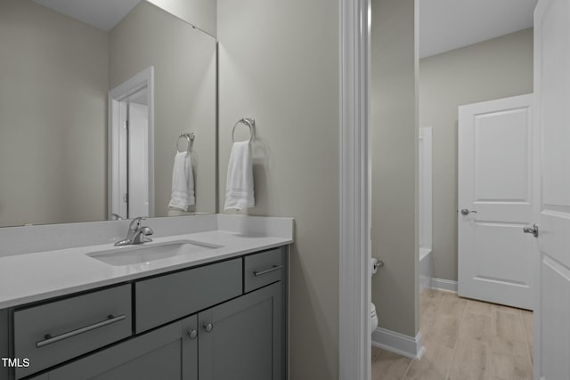 bathroom with vanity, toilet, and hardwood / wood-style floors