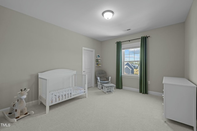 bedroom with a nursery area and light colored carpet