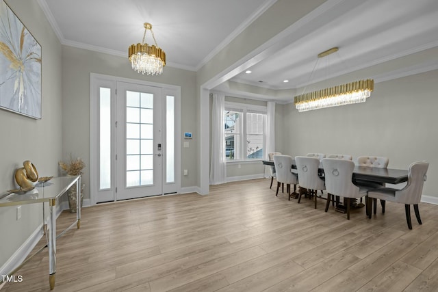 dining space with an inviting chandelier, crown molding, and light hardwood / wood-style flooring