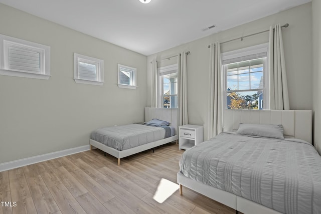 bedroom featuring light hardwood / wood-style floors and multiple windows