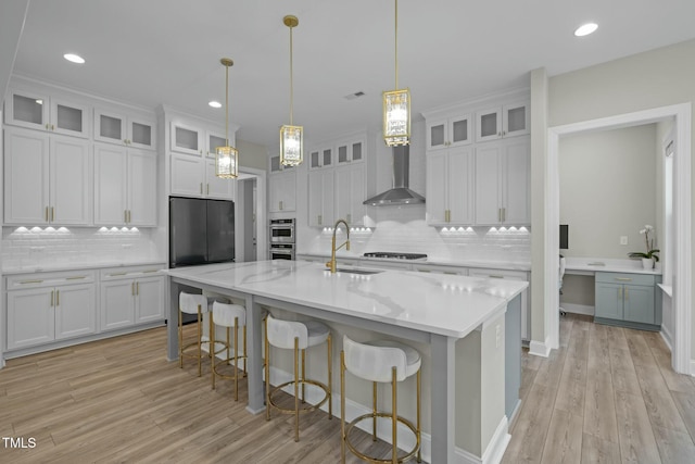 kitchen featuring sink, white cabinets, hanging light fixtures, a kitchen island with sink, and gas stovetop