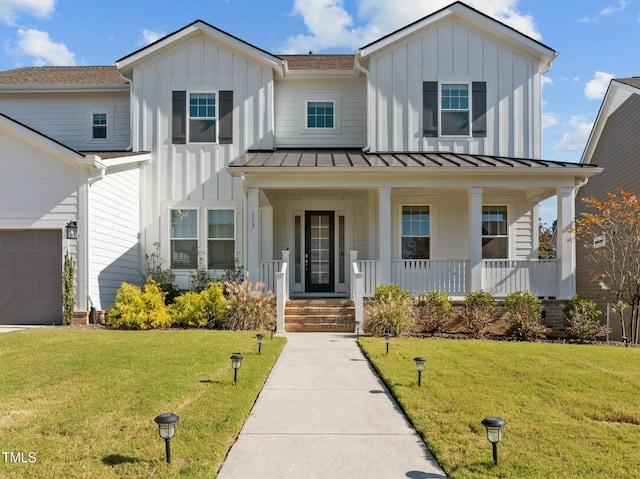 modern inspired farmhouse featuring covered porch and a front yard