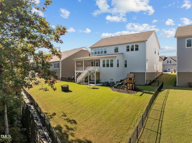 back of house with a yard and a playground