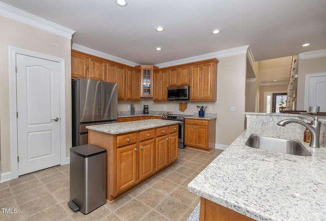 kitchen with a kitchen island, appliances with stainless steel finishes, sink, ornamental molding, and light stone counters