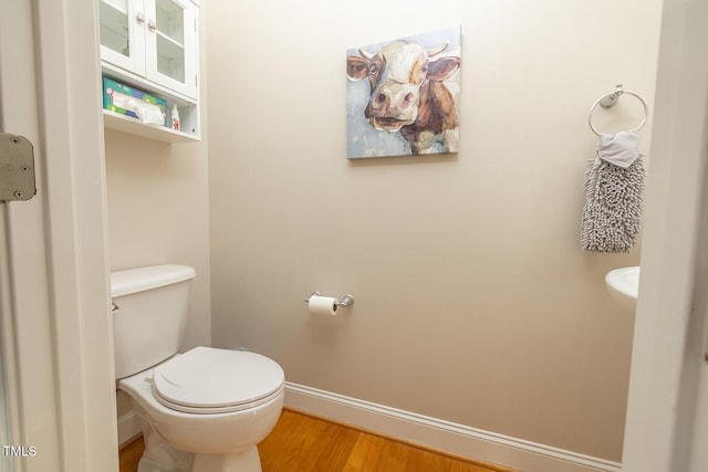 bathroom featuring hardwood / wood-style flooring and toilet