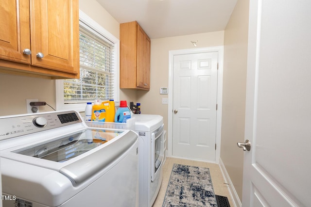 laundry room featuring independent washer and dryer and cabinets