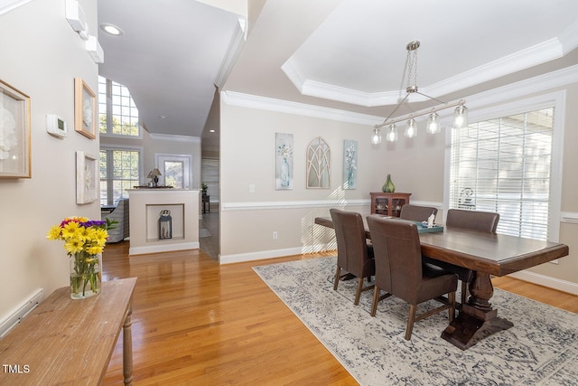 dining space with a baseboard radiator, ornamental molding, and light hardwood / wood-style flooring