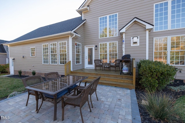 back of property with a deck and a patio