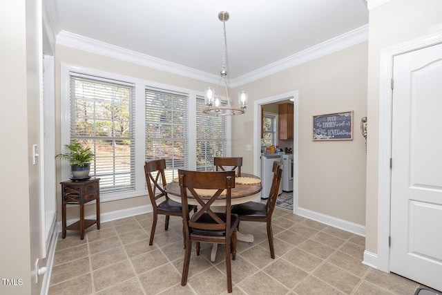 dining room featuring ornamental molding, separate washer and dryer, and an inviting chandelier