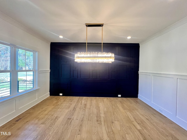 unfurnished dining area with ornamental molding and light hardwood / wood-style floors