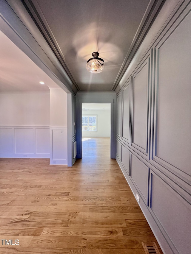 hall featuring light hardwood / wood-style floors and crown molding