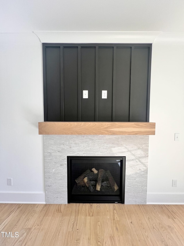 room details featuring a stone fireplace and wood-type flooring