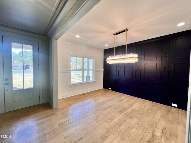 entryway featuring ornamental molding and light hardwood / wood-style flooring