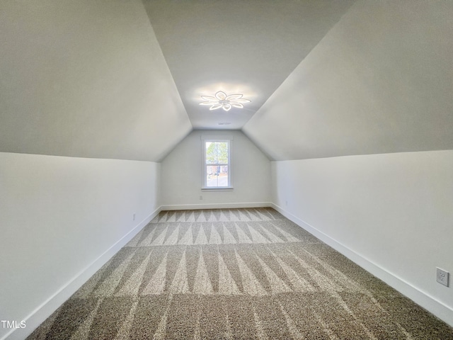 additional living space featuring light carpet and lofted ceiling