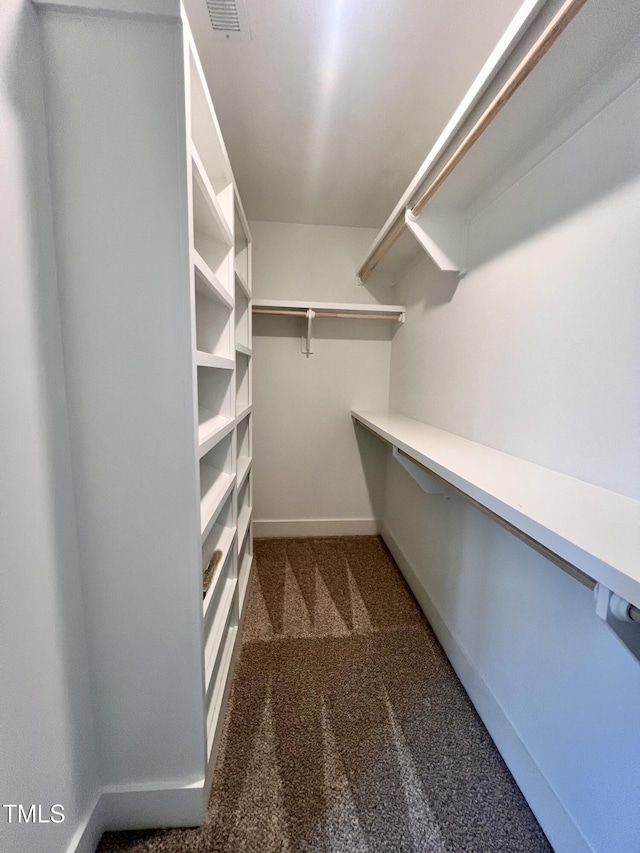 spacious closet featuring dark carpet