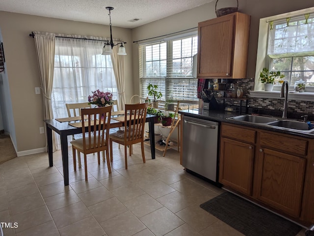 kitchen featuring sink, a textured ceiling, hanging light fixtures, dishwasher, and backsplash