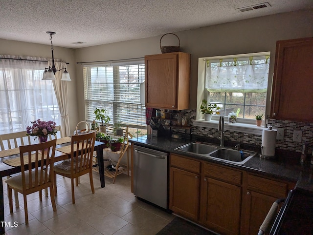 kitchen with tasteful backsplash, sink, decorative light fixtures, and stainless steel dishwasher