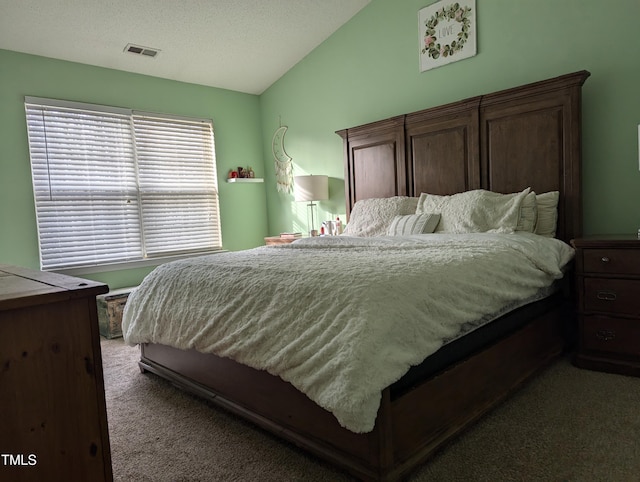 carpeted bedroom featuring vaulted ceiling and a textured ceiling